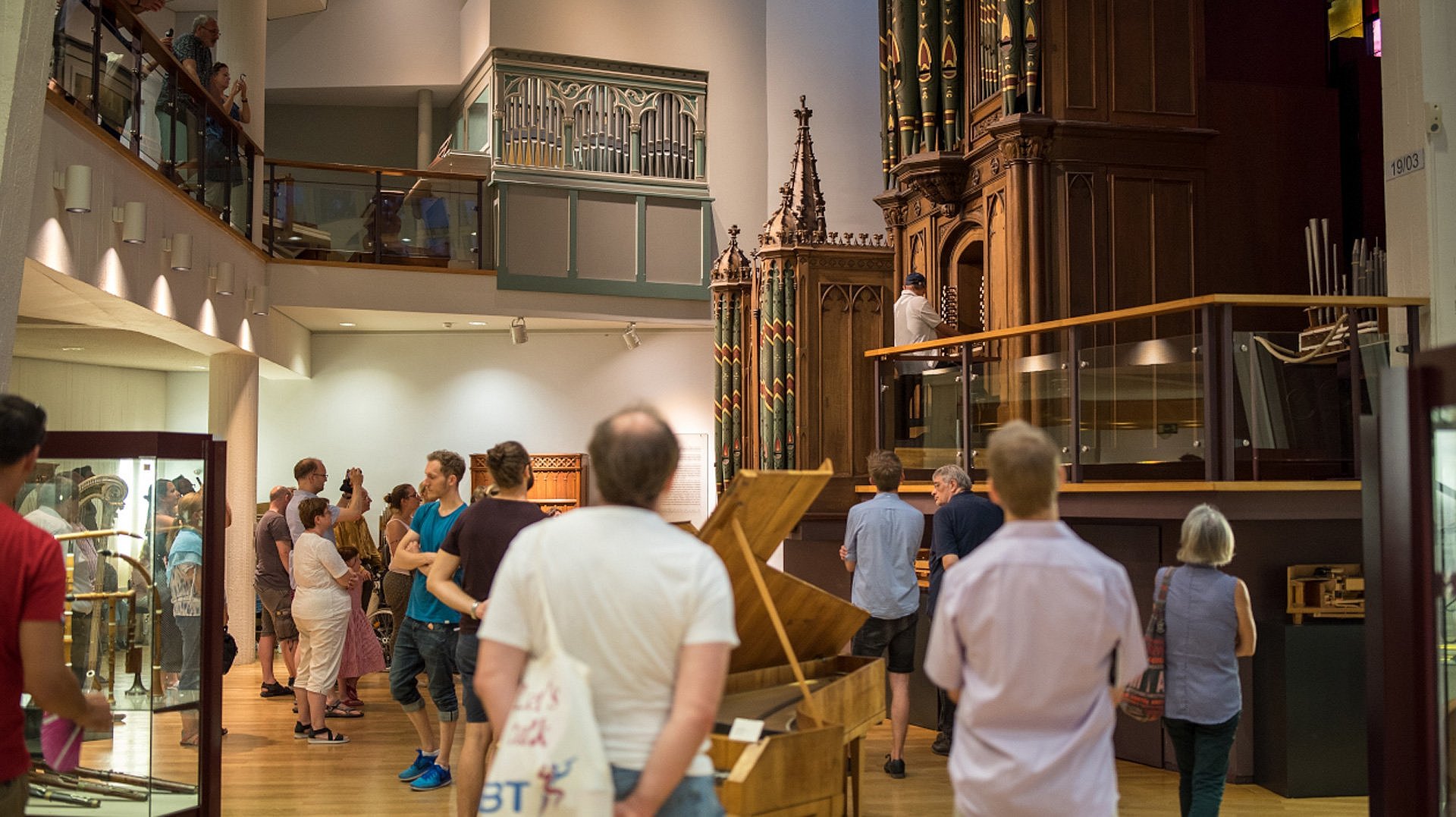 Besucher in einem Musikinstrumenten-Museum mit Orgel