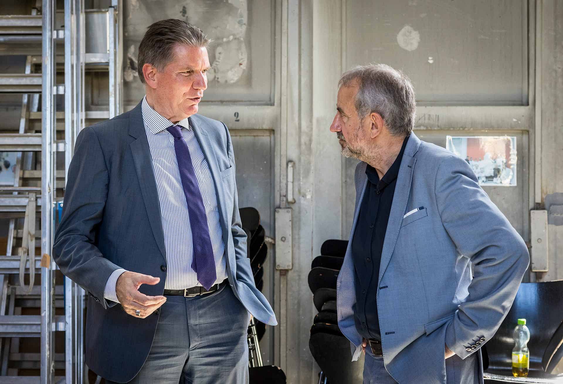Zwei Männer in Anzügen unterhalten sich
