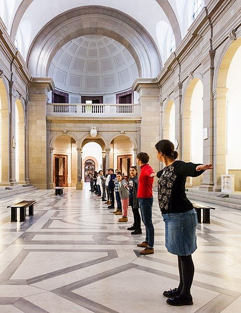 Eine Menschenkette in einem Ausstellungsraum.