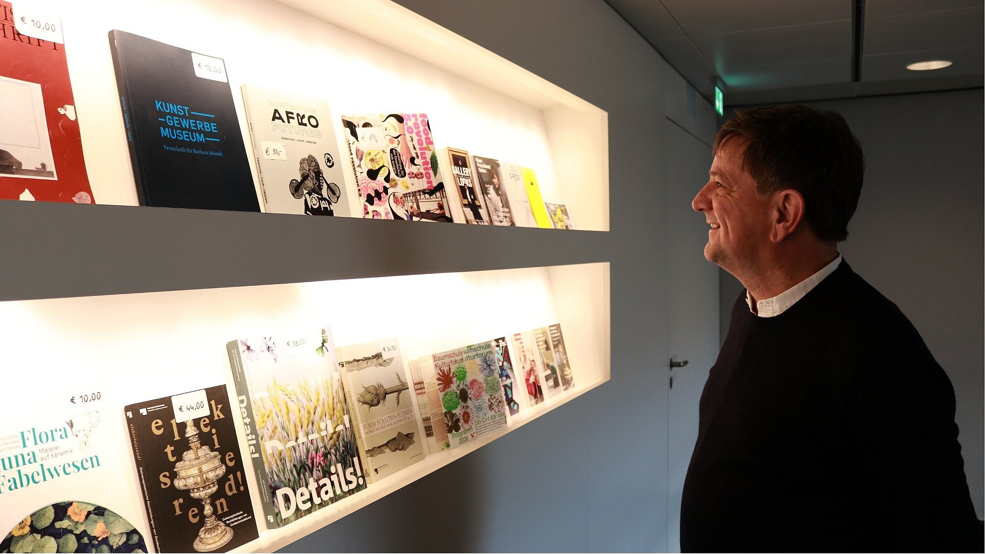 Ein Mann vor einer Katalog-Wand