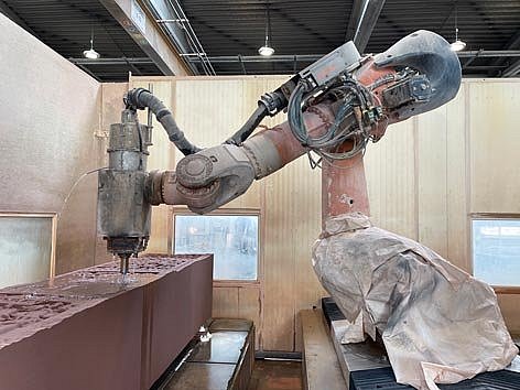 Ein Roboter fräst Motive in einen riesigen Sandsteinblock