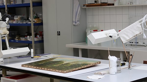 Gemälderestaurierung Gemälde auf einem Arbeitstisch