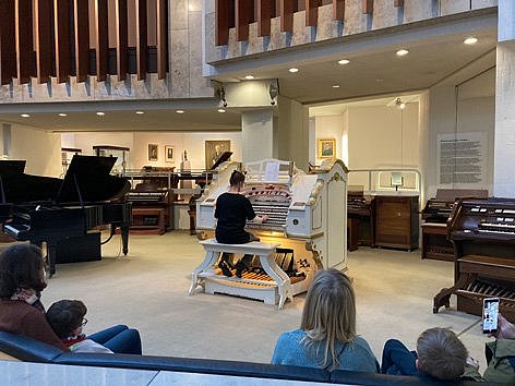 Eine Frau spielt eine Kinoorgel in einem Museum