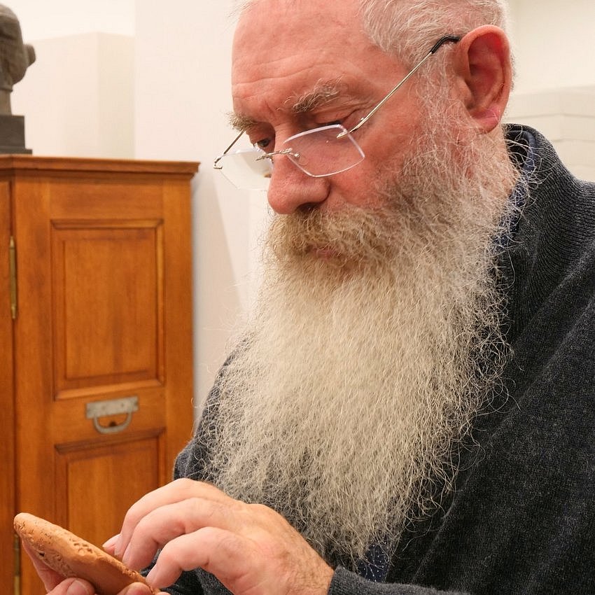 Mann betrachtet Tontafel