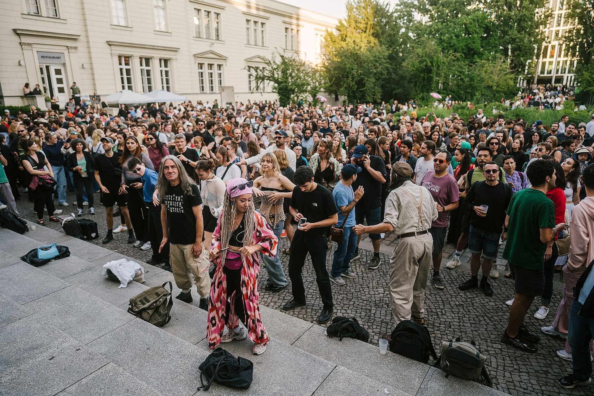 Eine große Gruppe von tanzenden Menschen in einem Innenhof