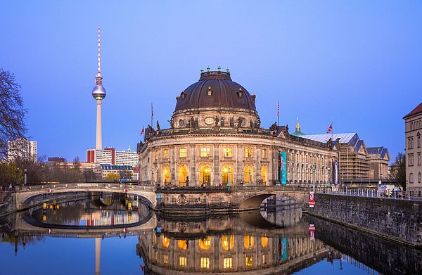 Blick auf das Bode-Museum mit einer dunklen Kuppel vor dem Berliner Abendhimmel, im Hintergrund ist der Fernsehturm zu sehen