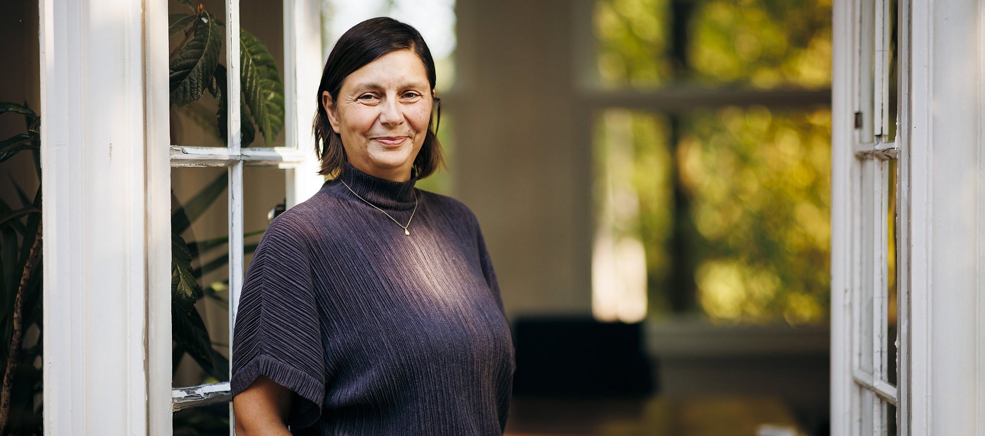 Portrait einer Frau vor einer weißen Tür