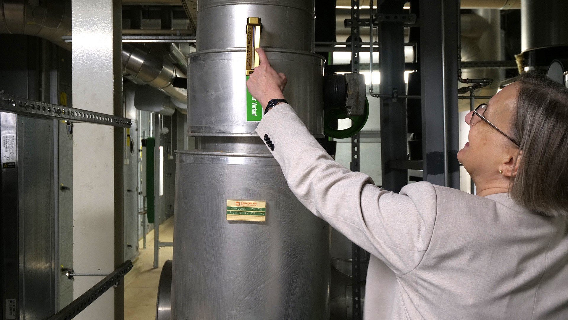 Frau zeigt auf Thermometer