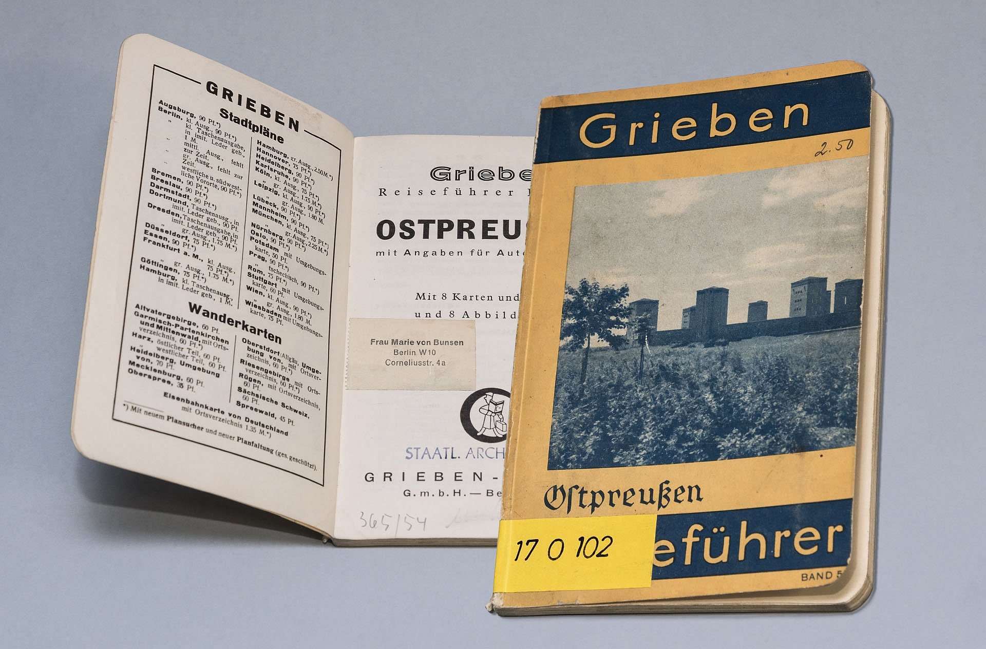 Alter Reiseführer aufgeschlagen und geschlossen nebeneinander.