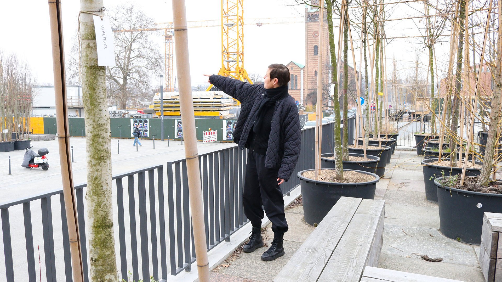 Frau zeigt auf Gebäude