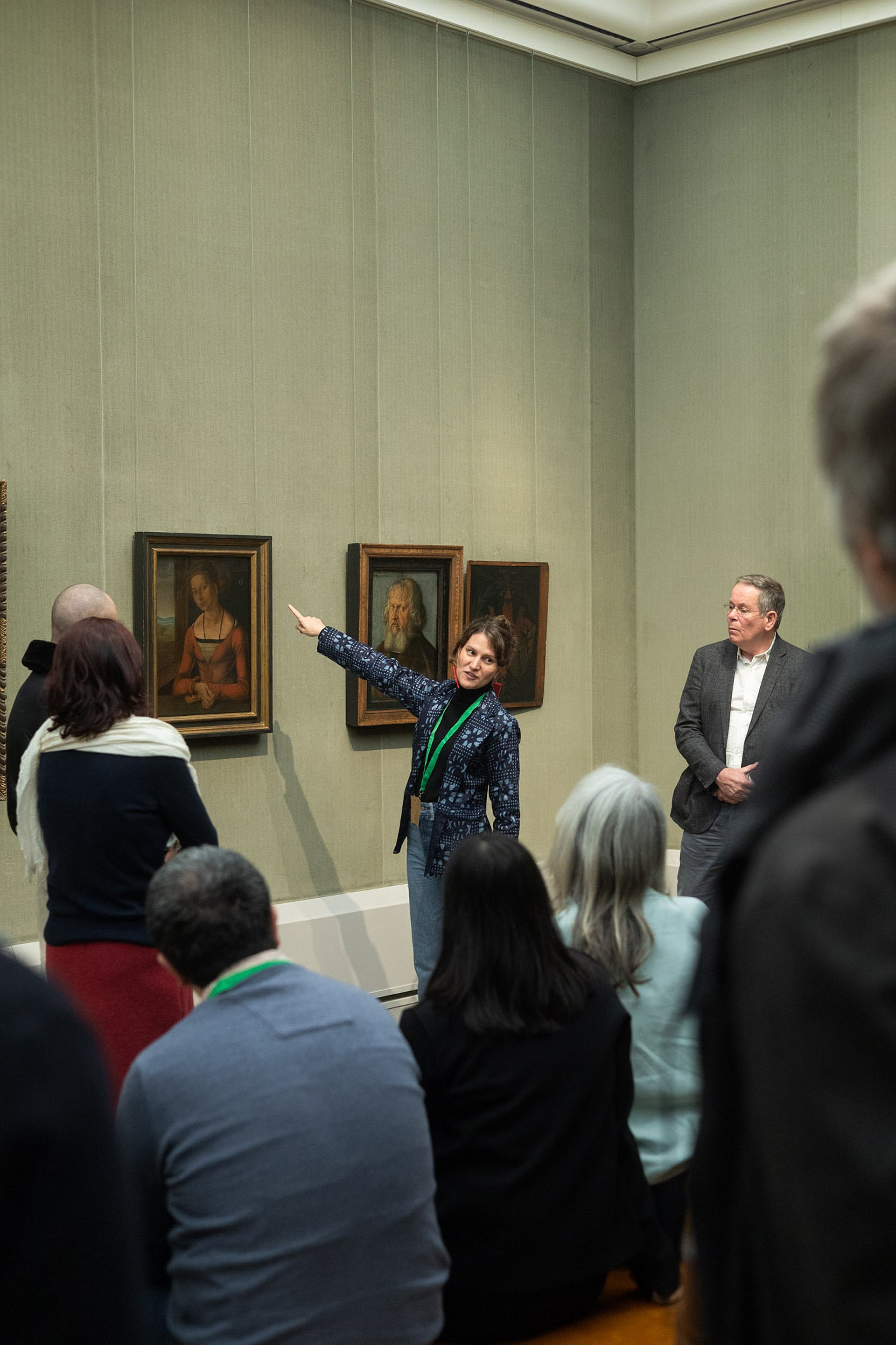 Frau zeigt in Museum auf Bild