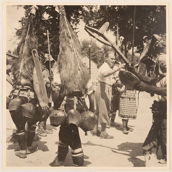 Sepiaaufnahme eines Mannes umgeben von mehreren Personen