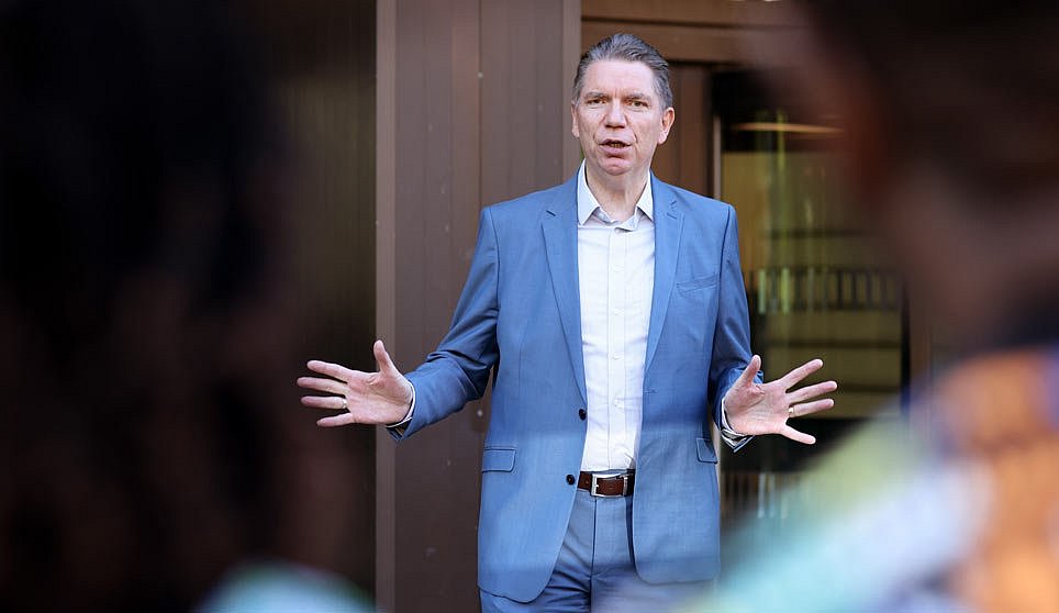 Lars-Christian Koch spricht vor einer Gruppe von internationalen Gästen