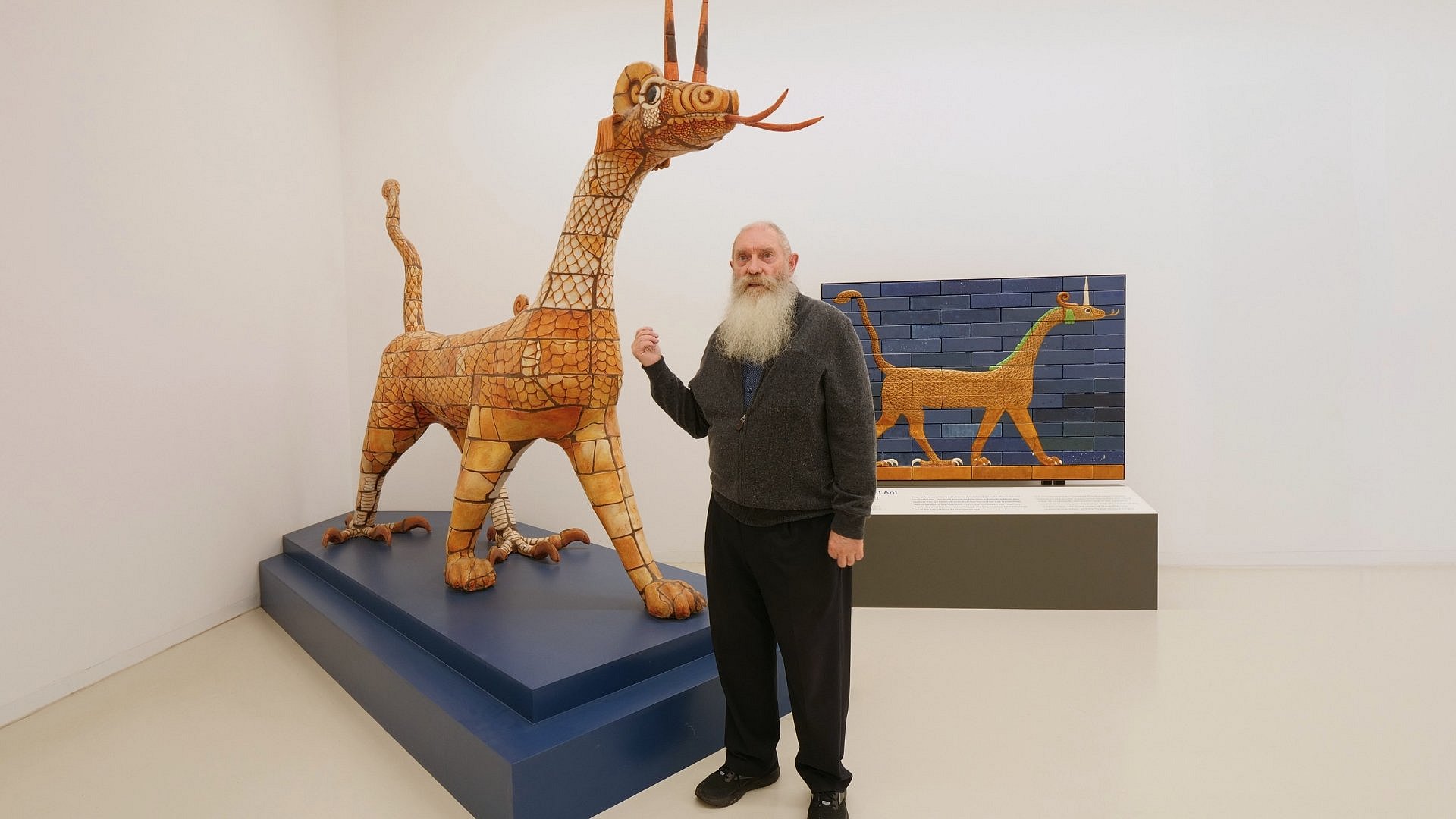 Mann neben einer großen drachenartigen Skulptur