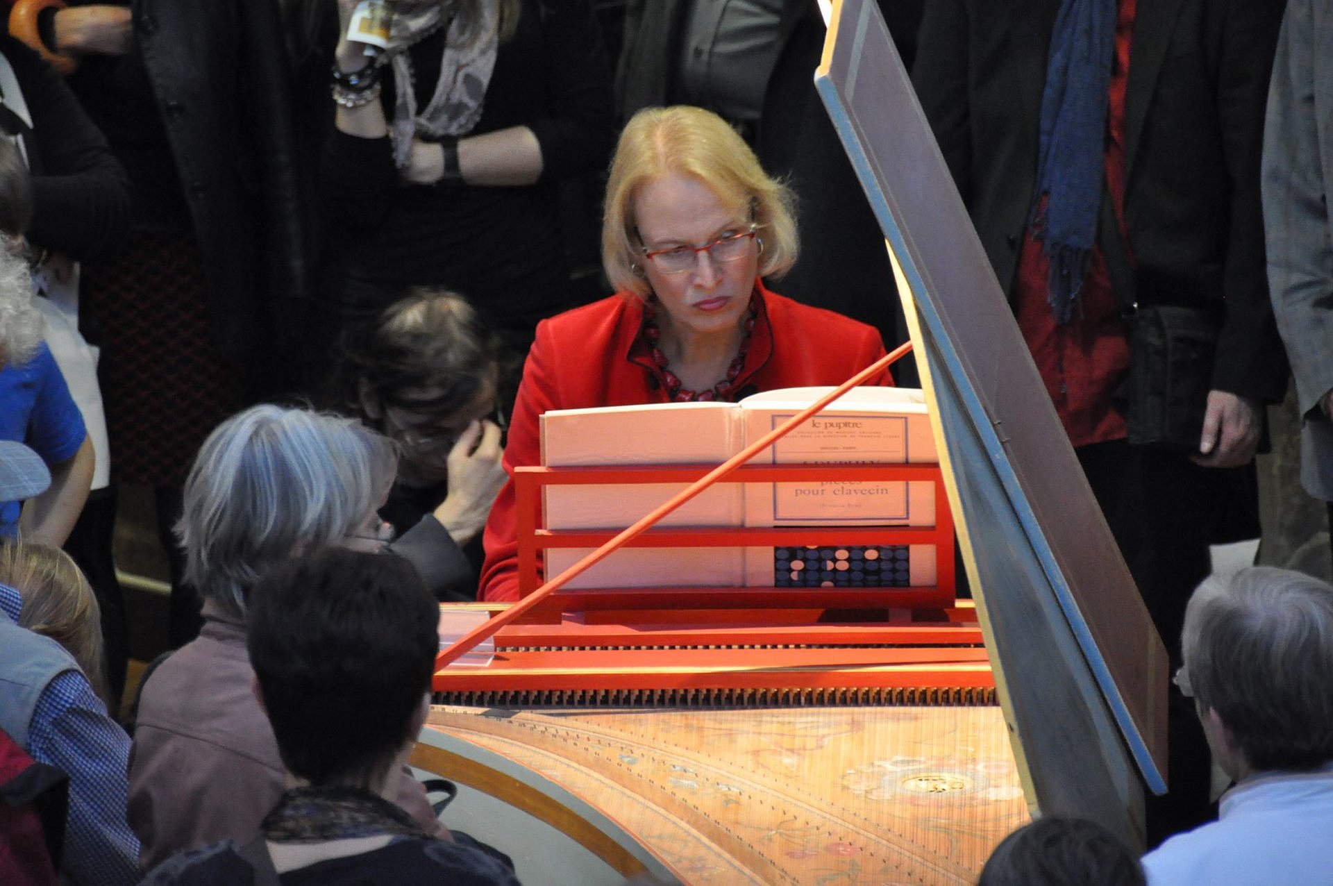 Eine Frau spielt für eine Menge an Menschen Piano