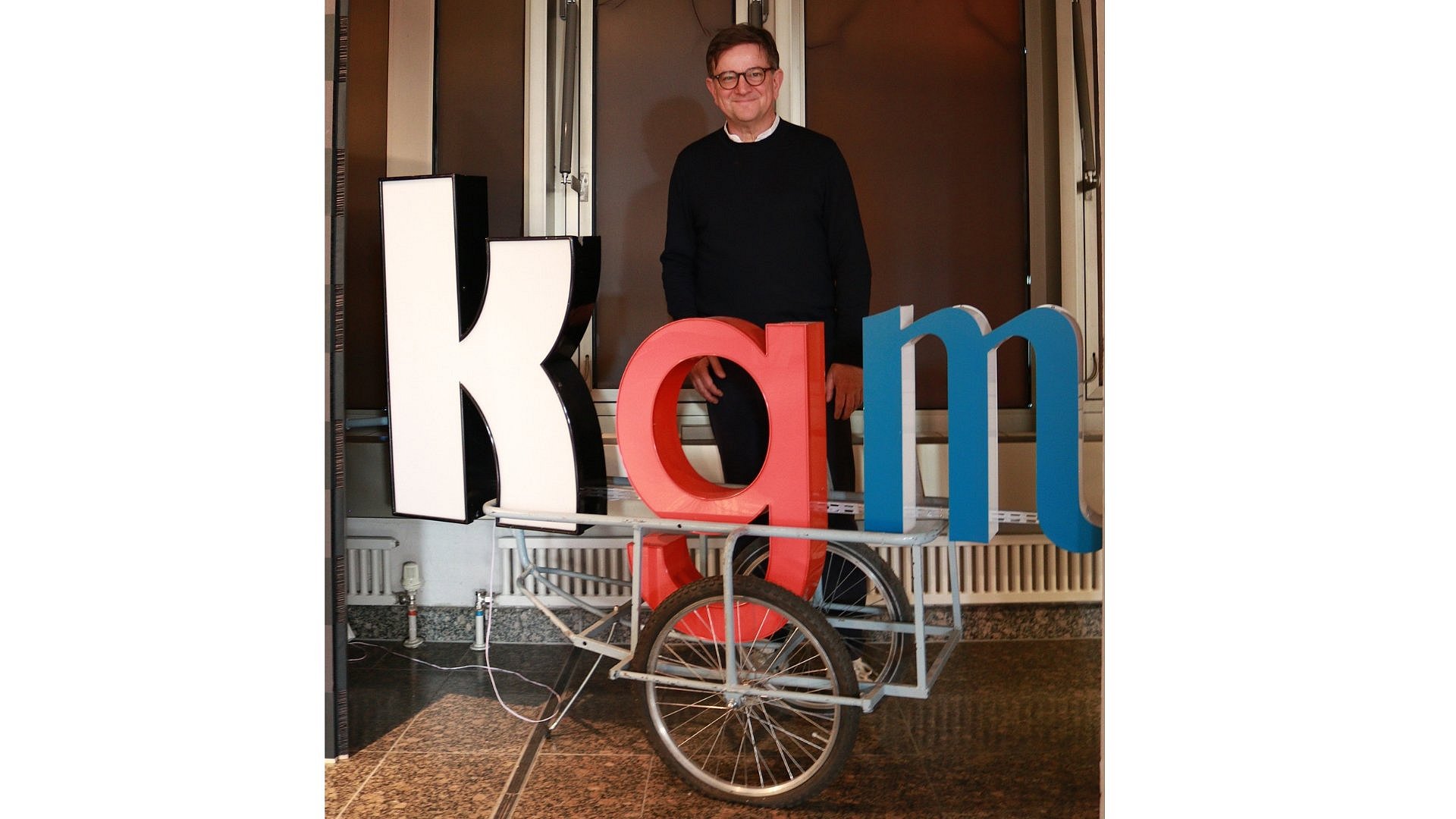 Ein Mann hinter einem KGM-Schriftzug