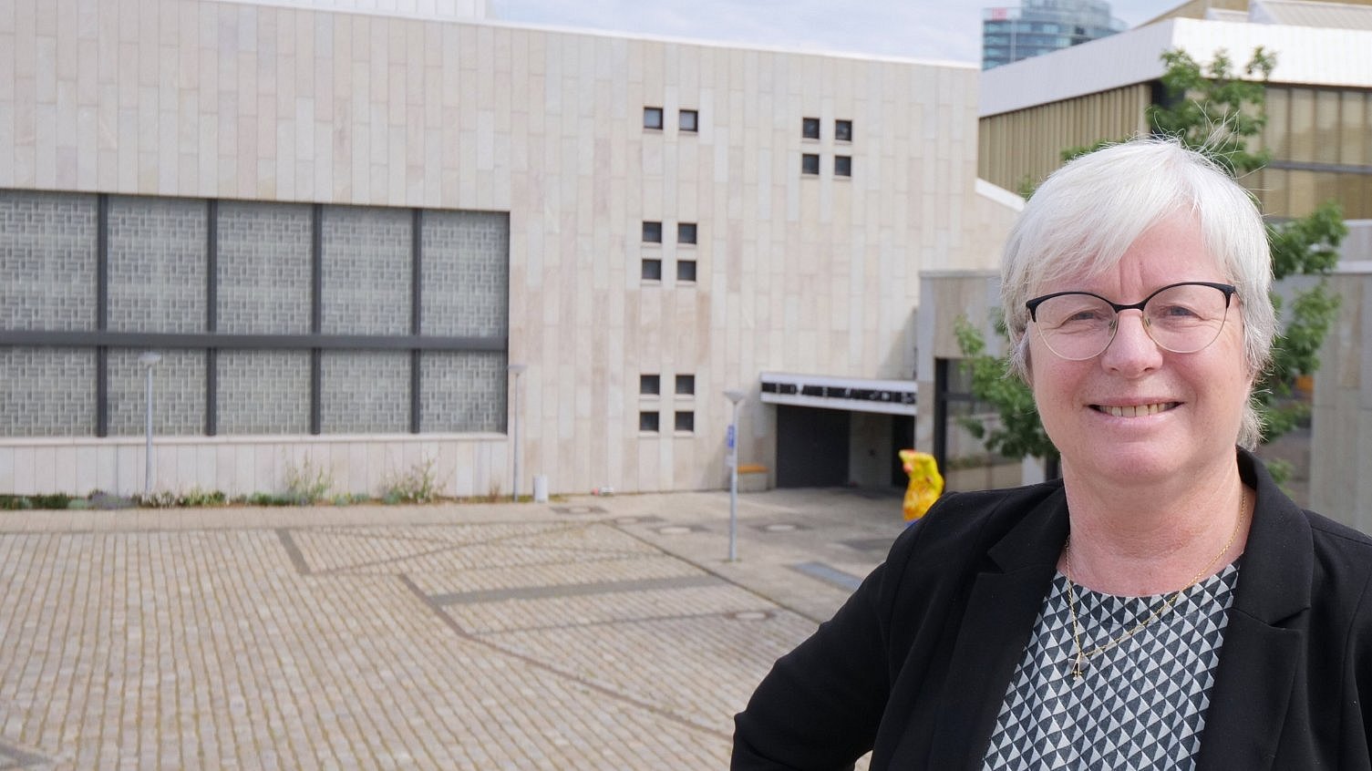 Eine Frau steht vor einem Forschungsinstitut