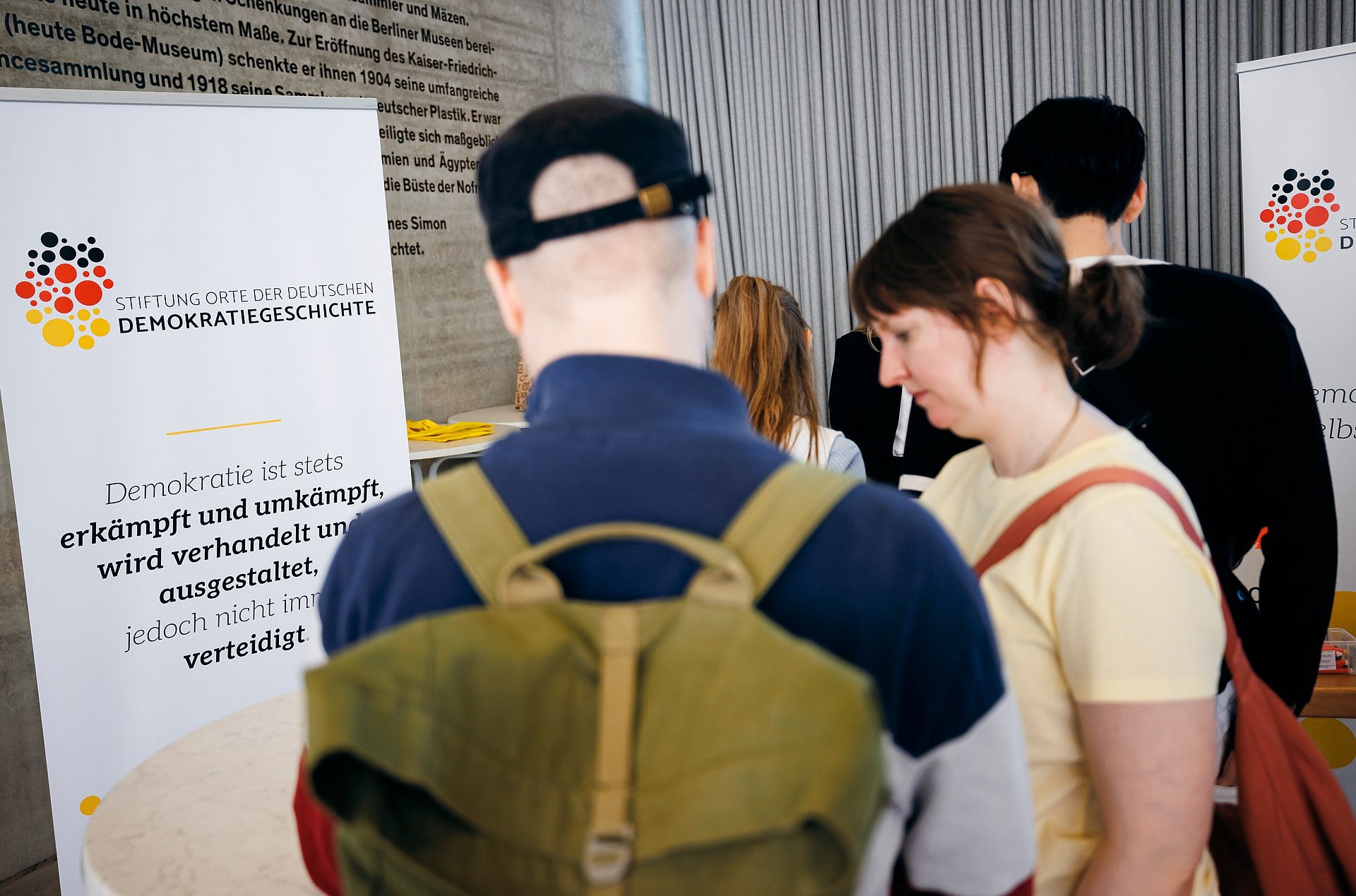 Personen betrachten eine Infowand