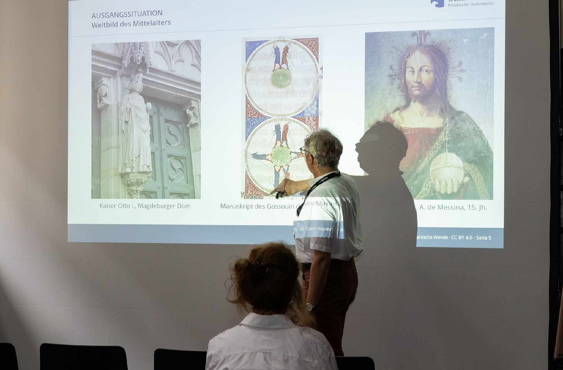 Mann vor Leinwand, wird von Beamer angestrahlt