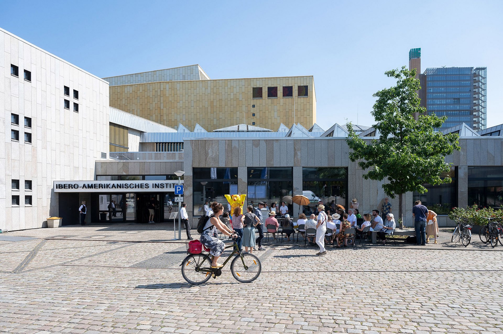 Straßenszene mit vielen Menschen vor einem Forschungsinstitut