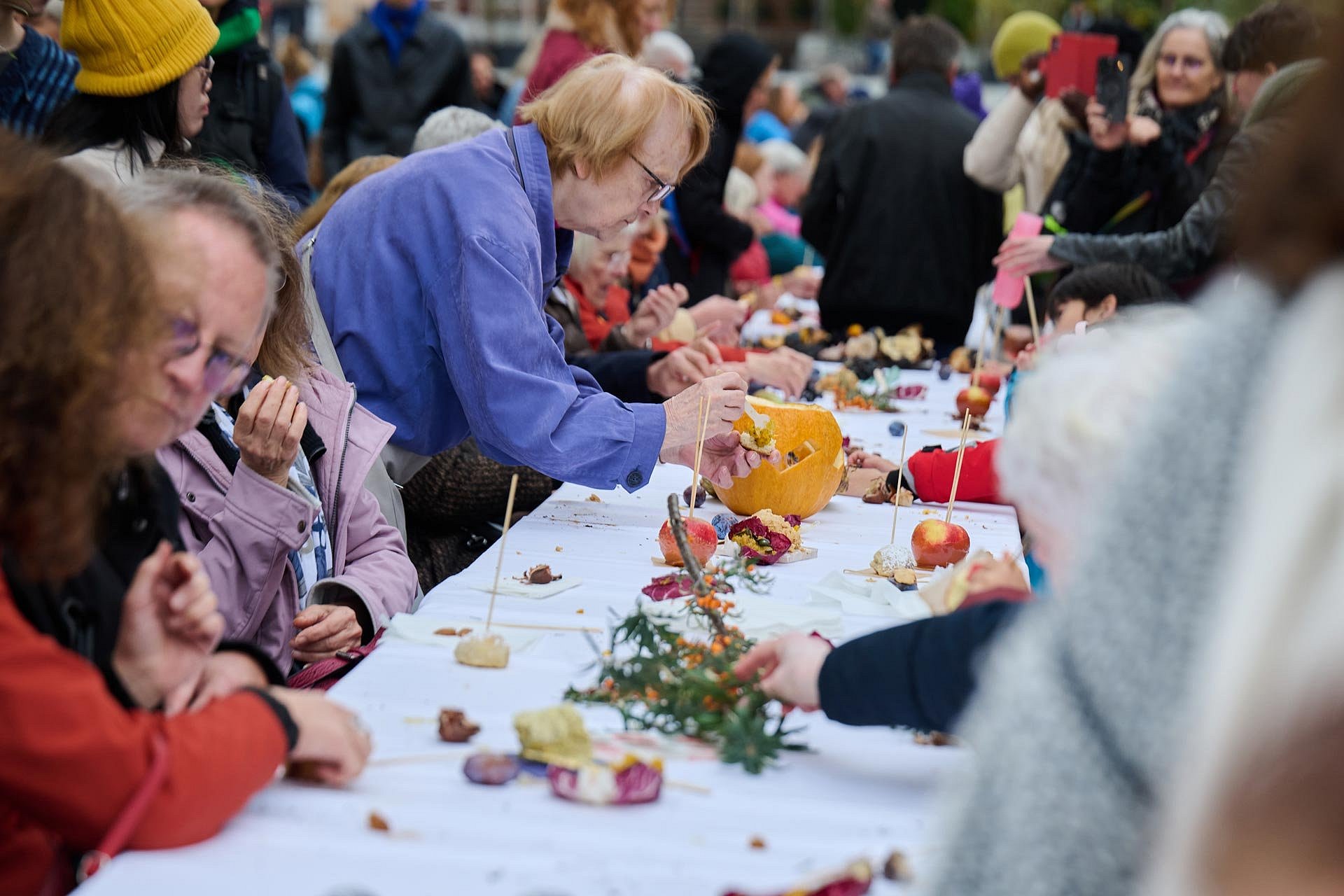 Personen essen an einer langen Tafel