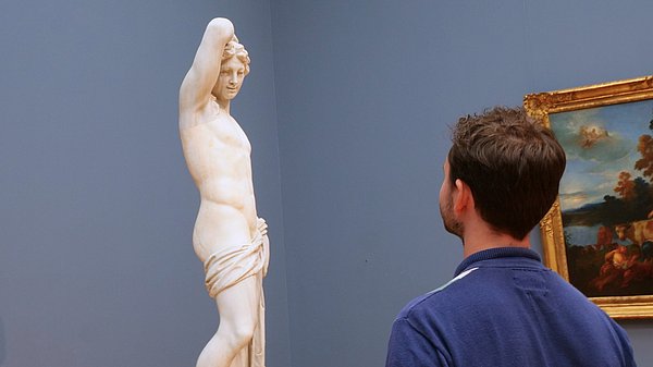 Ein Mann vor einer Mamor-Plastik