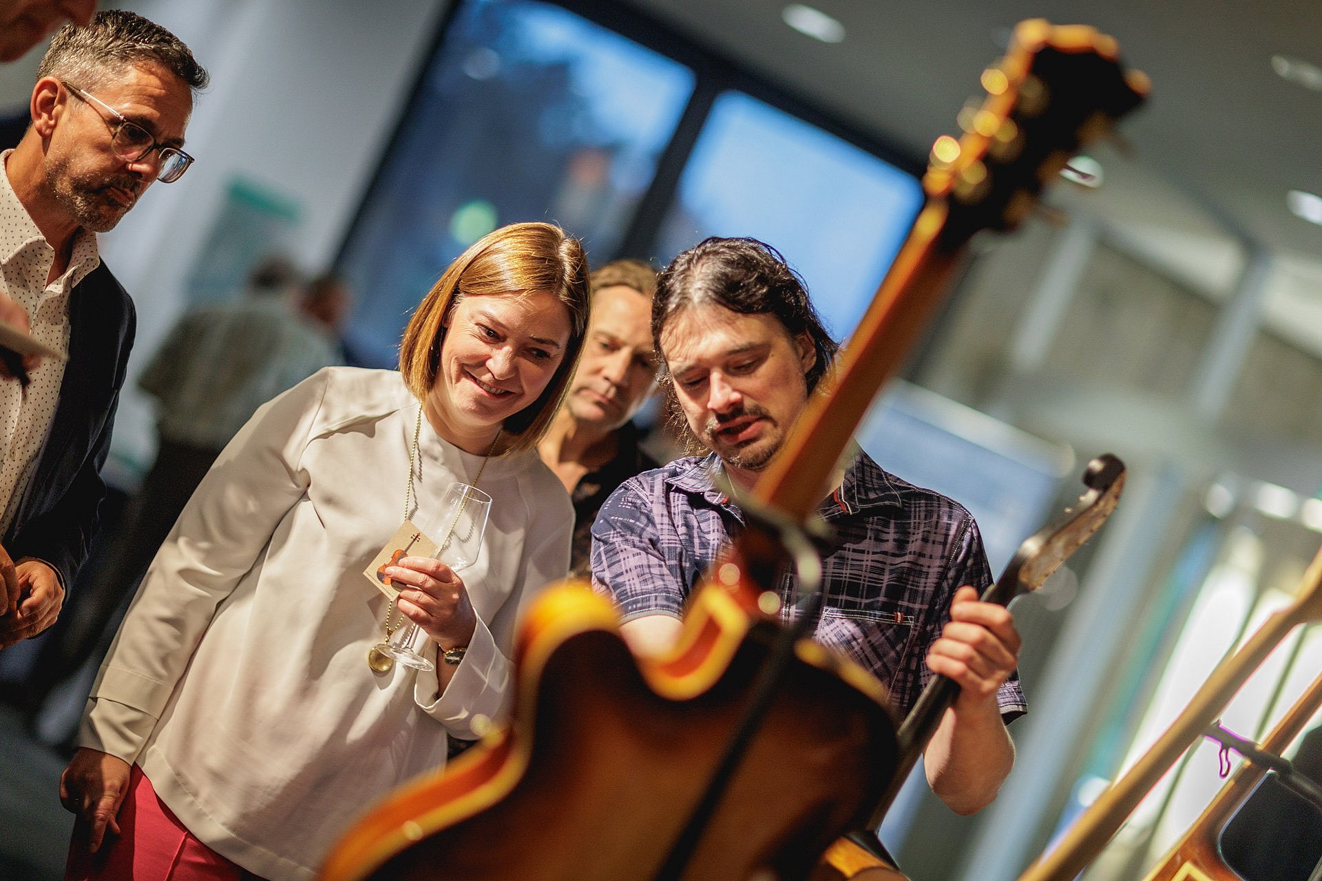 Personen sprechen über eine im Museum ausgestellte Gitarre