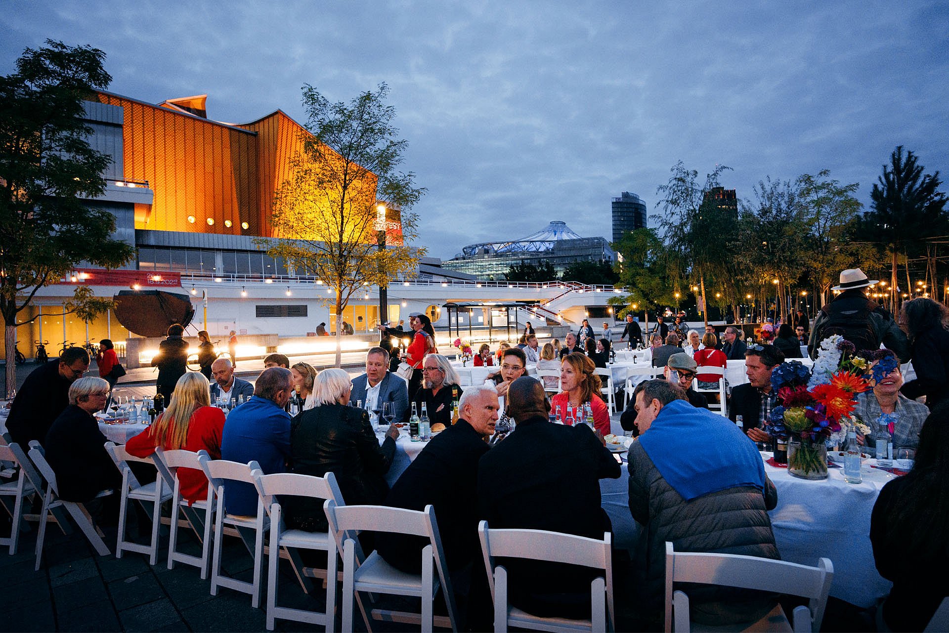 Menschen an einer Festtafel in der Dämmerung