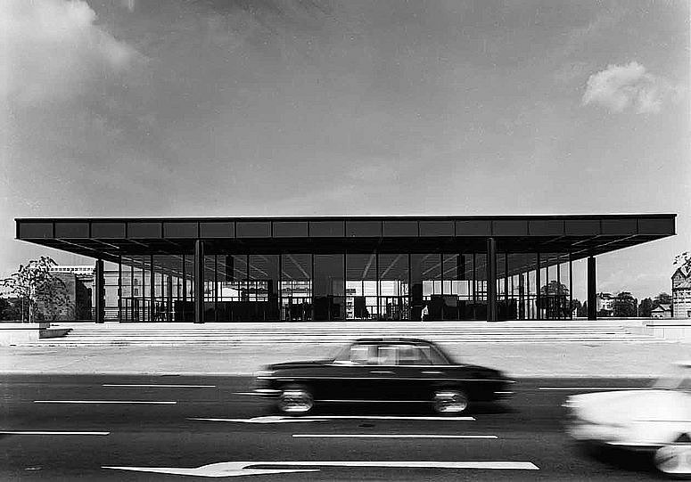 Schwarz-Weiß Fotografie mit Blick auf ein modernes Gebäude hinter einer befahrenen Straße (öffnet Vergrößerung des Bildes)
