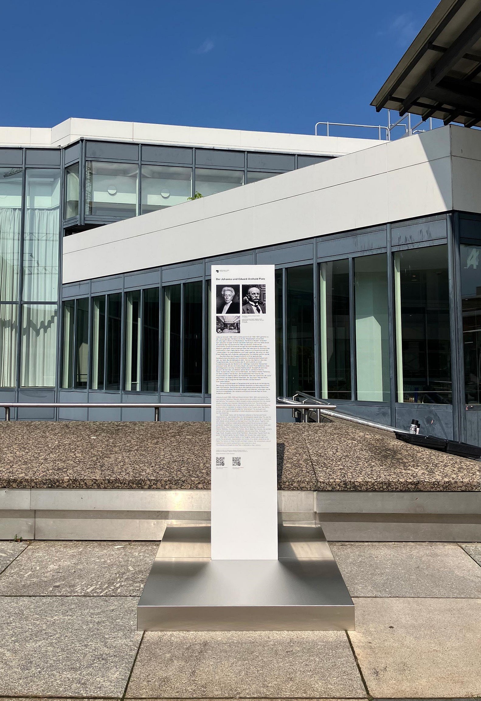 Gedenkstele mit Bild und Text vor einem Museum