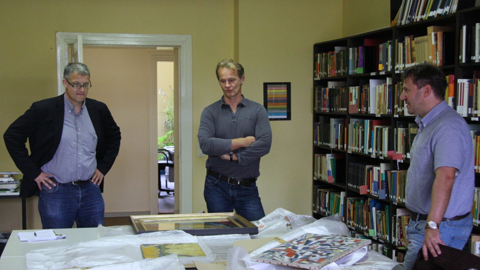 Three men standing in a room