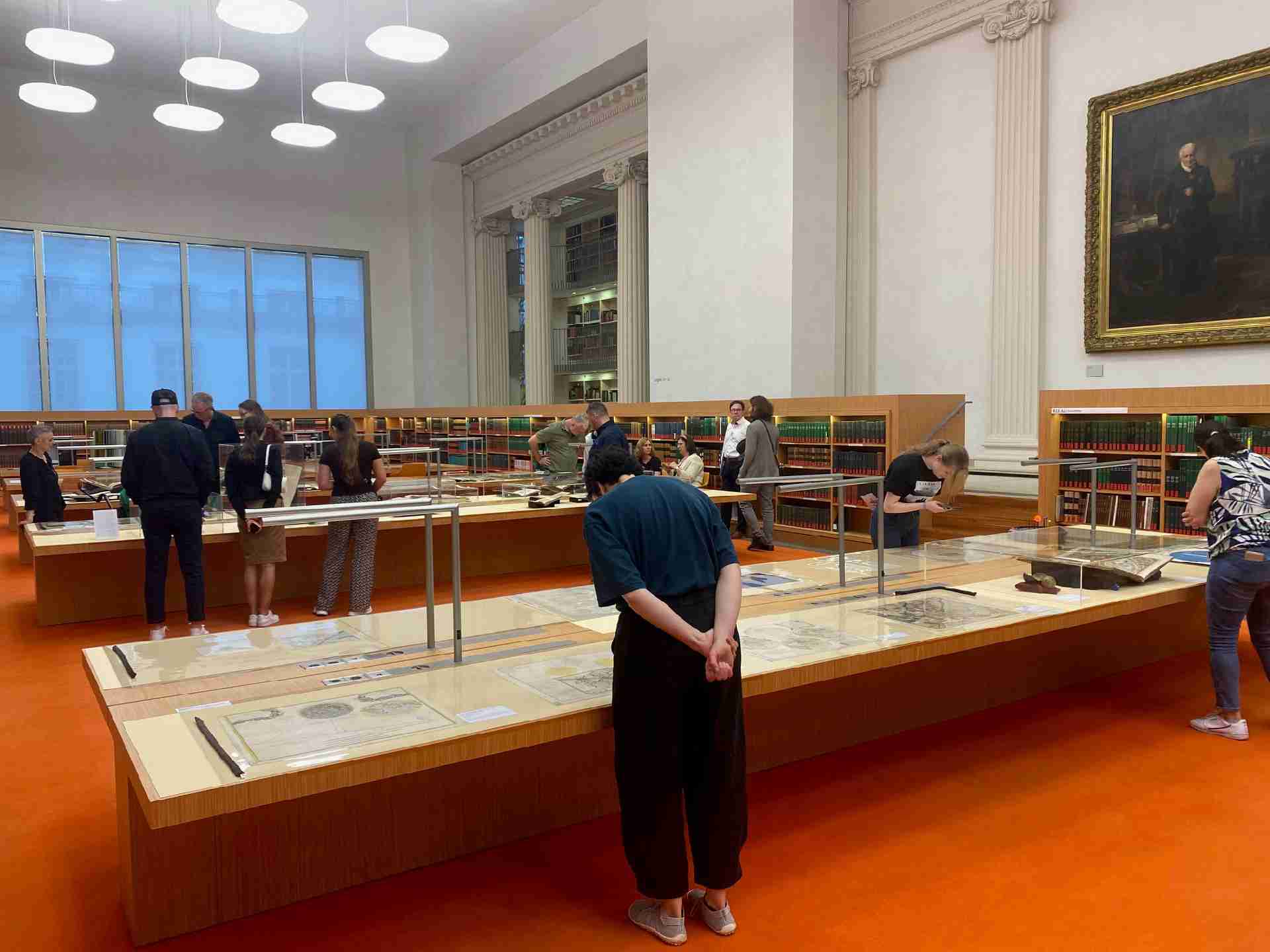 Blick in einen großen Bibliothekssaal mit Büchern und Exponaten