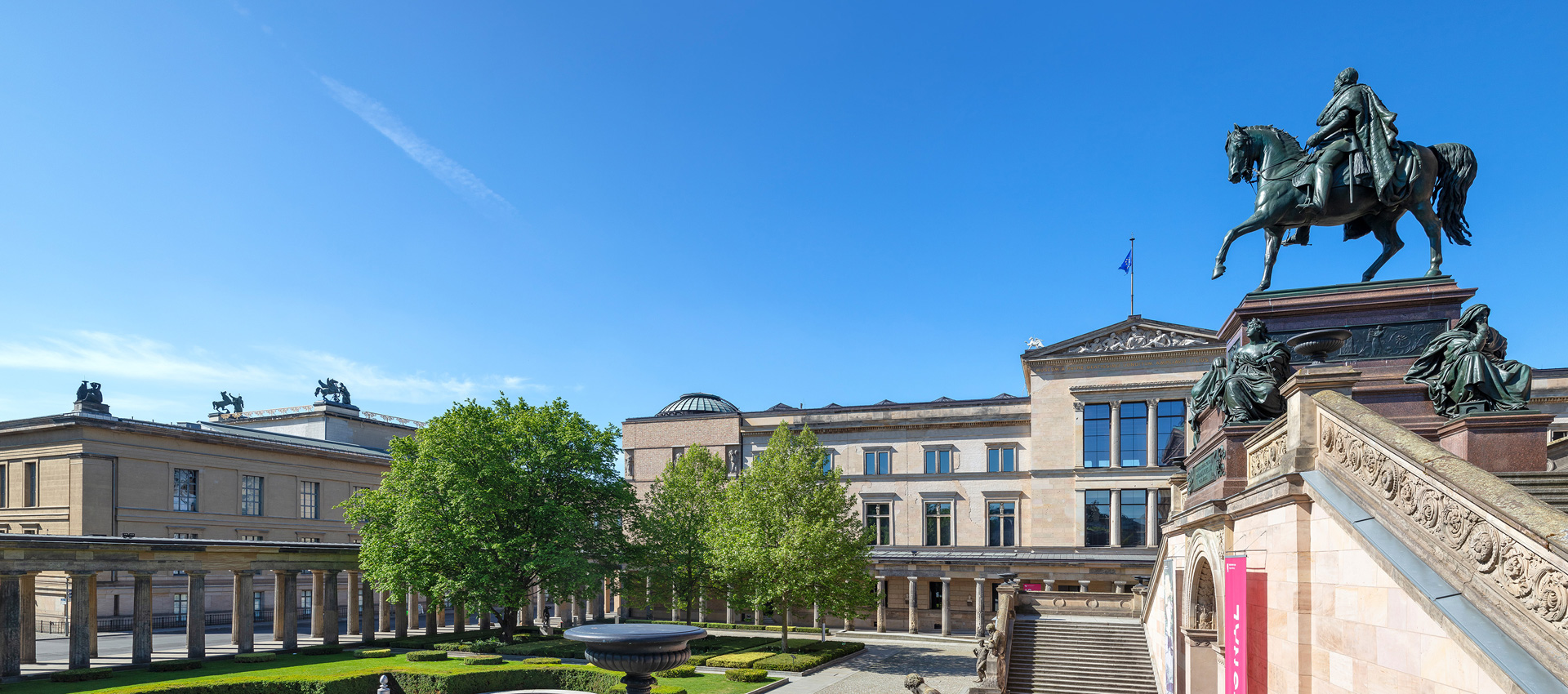 Blick auf einen Kolonnadenhof, Museumsgebäude, Reiterfigur und Treppe