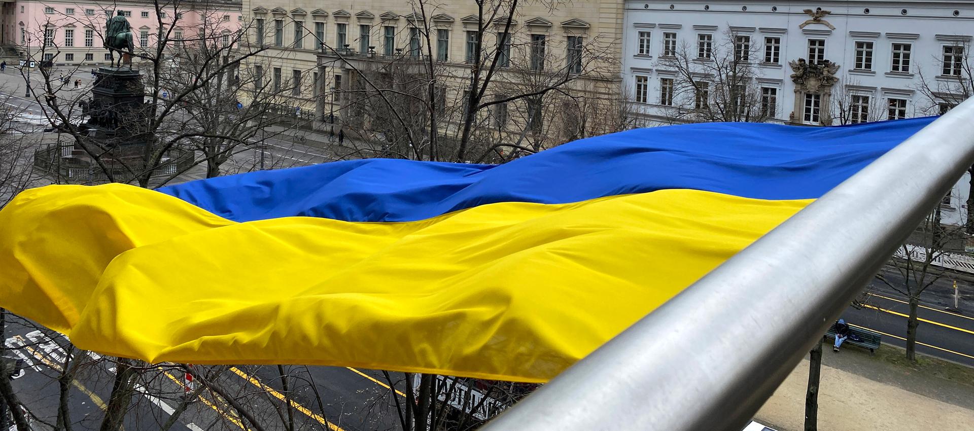 Ukrainische Flagge in gelb und blau weht über der Straße Unter den Linden, Berlin